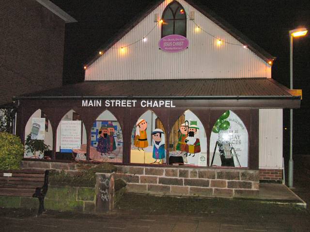 Outside the church at night showing lights and window paintings